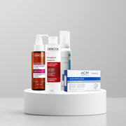 Collection of hair care products on a white platform with a gray background